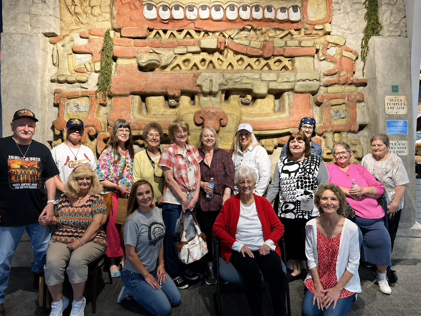 Autumn Ridge residents on a group outing, posed together in front of a Maya temple exhibit